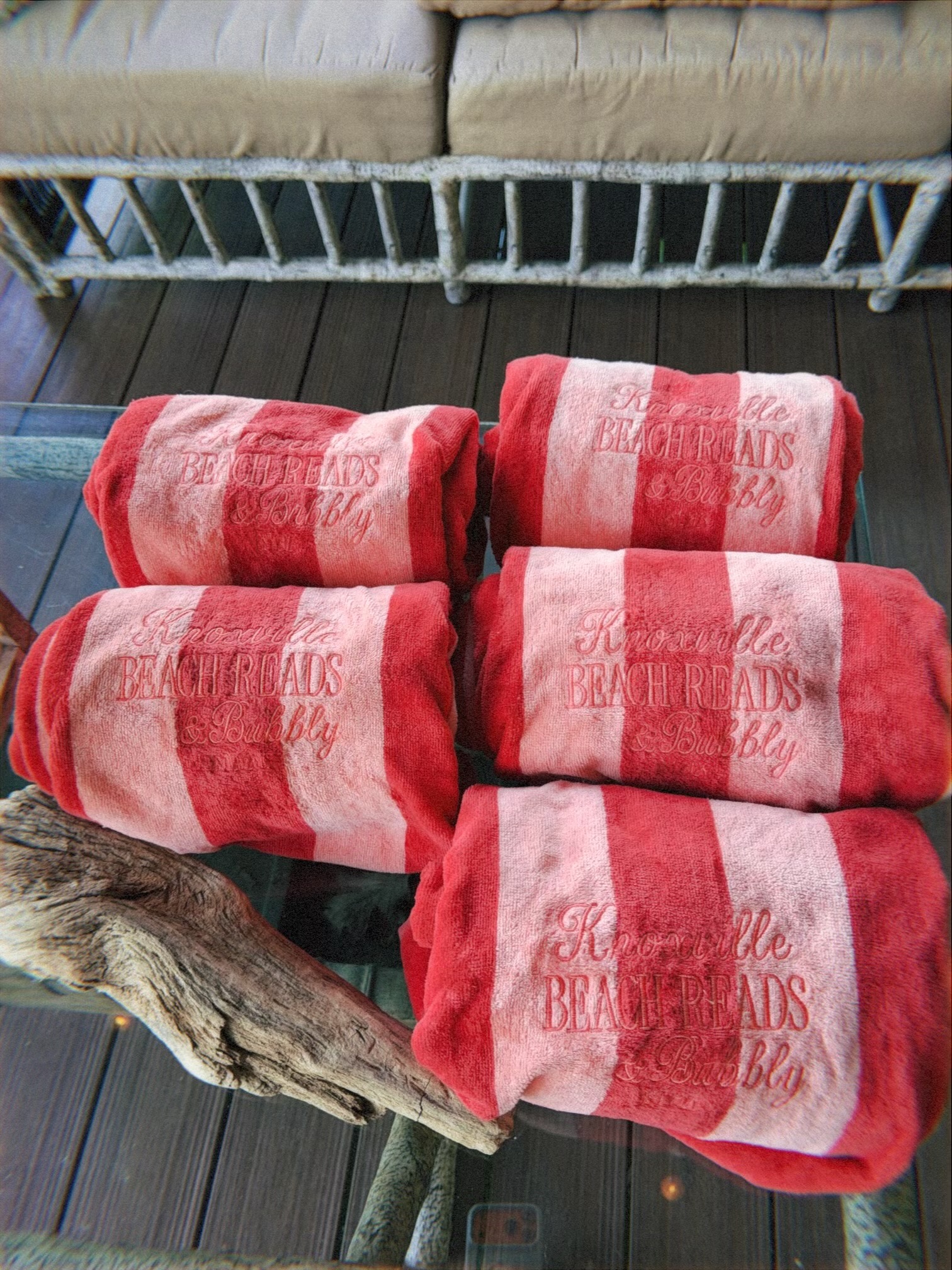 Stack of red-and-white striped beach towels embroidered Knoxville Beach Reads & Bubbly