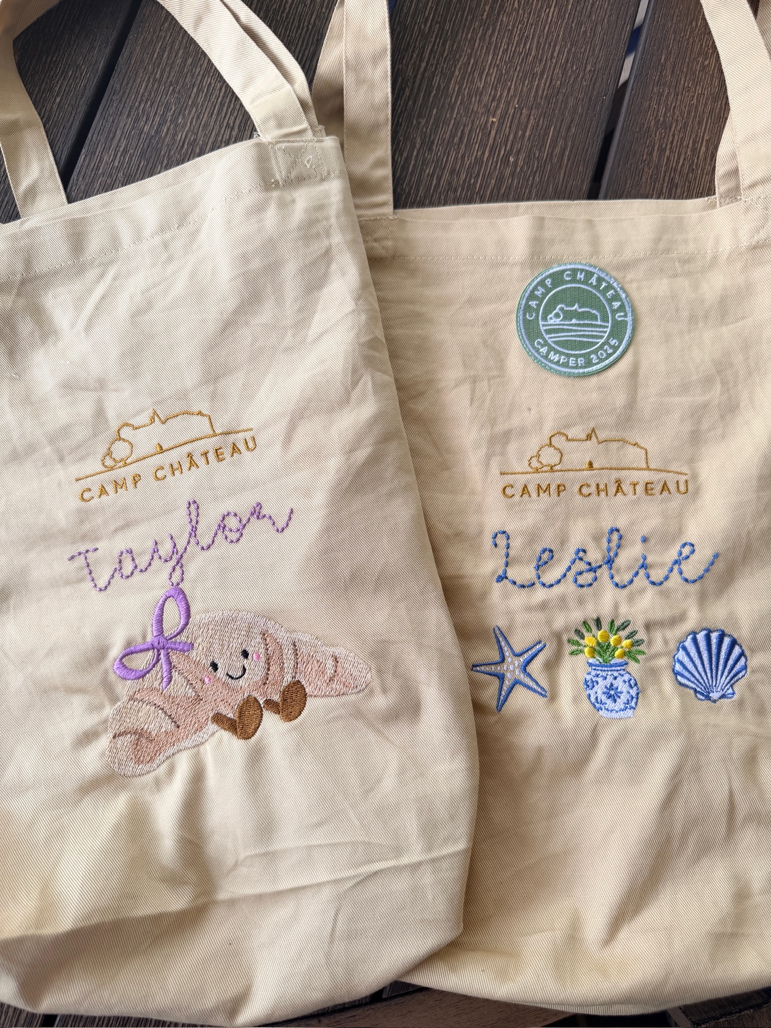 Two Camp Château totes embroidered for Taylor and Leslie with a croissant, starfish, ginger jar and shell